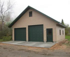 vinyl sided garage with two large doors and a service door - Construction in Upper Peninsula of Michigan