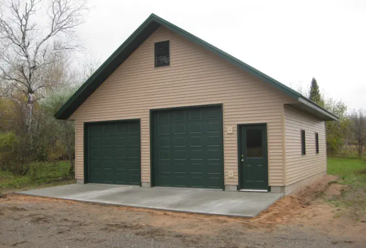 vinyl sided garage with two large doors and a service door - Construction in Upper Peninsula of Michigan