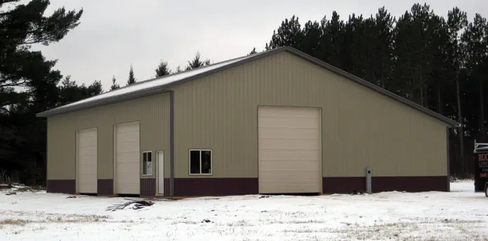 Pole barn construction with steel siding and three large doors - Construction in U.P. of Michigan