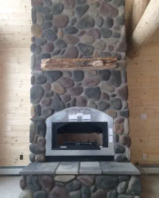 large stone fireplace in new wood cabin
