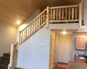 home addition with loft and log railing on stairs