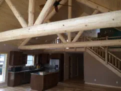 interior of open concept house with log beams