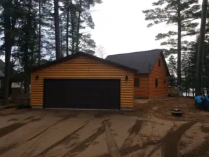 garge with log siding and double stall garage doors