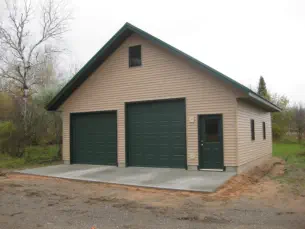 garage with two garage doors on concrete foundation and vinyl siding