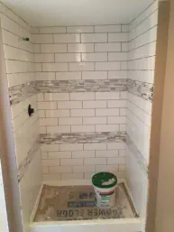 shower stall with white and gray tiles