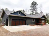 one story home in woods with attached garage